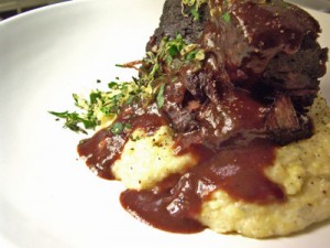 Beef Short Ribs Braised in a Red Wine, Served with Creamy Polenta, Green Peas, Carrots